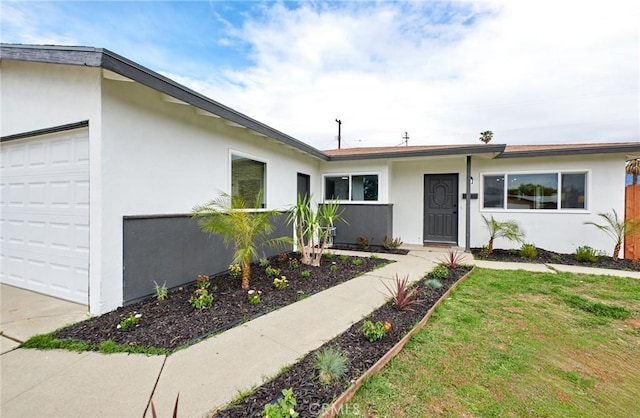 ranch-style house featuring stucco siding and a garage