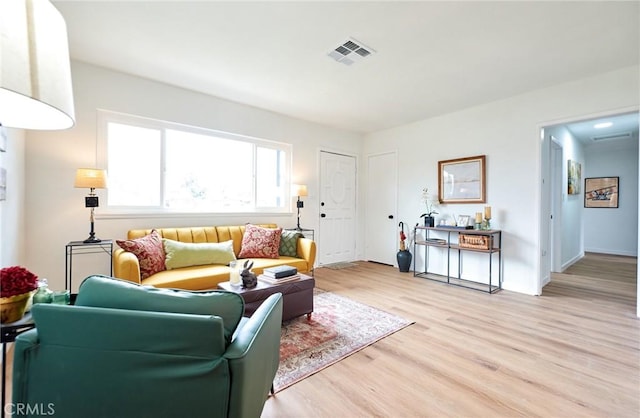 living room featuring visible vents and light wood-style flooring