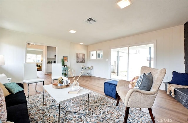 living room featuring light wood finished floors and visible vents