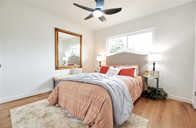 bedroom featuring wood finished floors, baseboards, and ceiling fan