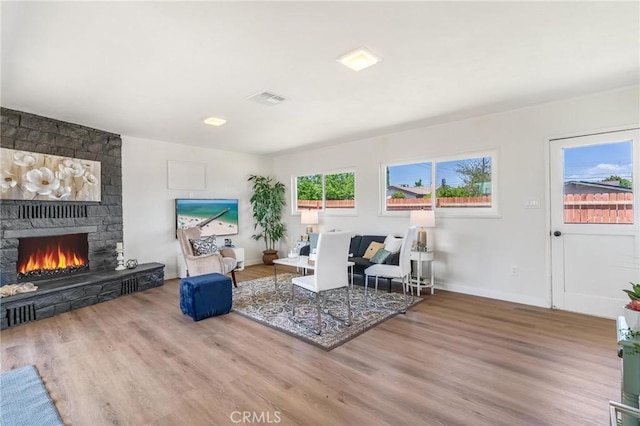 19436 Chaparral St, Rialto, CA 92376 - living area with a stone fireplace, wood finished floors, and baseboards