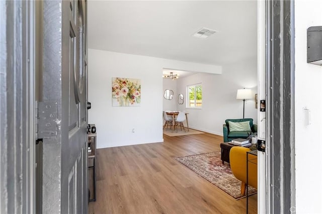entryway featuring wood finished floors, baseboards, and a chandelier