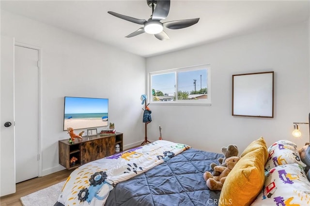 bedroom with wood finished floors, ceiling fan, and baseboards