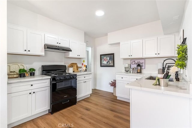 kitchen featuring black gas stove, under cabinet range hood, white cabinetry, light wood finished floors, and recessed lighting