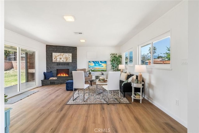living room with plenty of natural light, a fireplace, wood finished floors, and baseboards