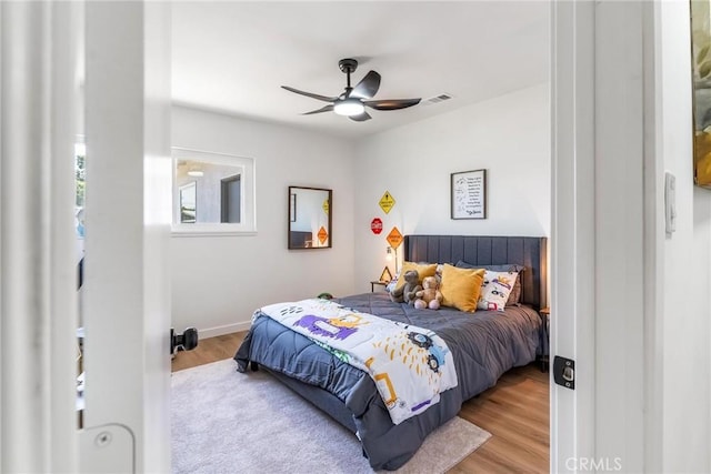 bedroom with wood finished floors, ceiling fan, and baseboards