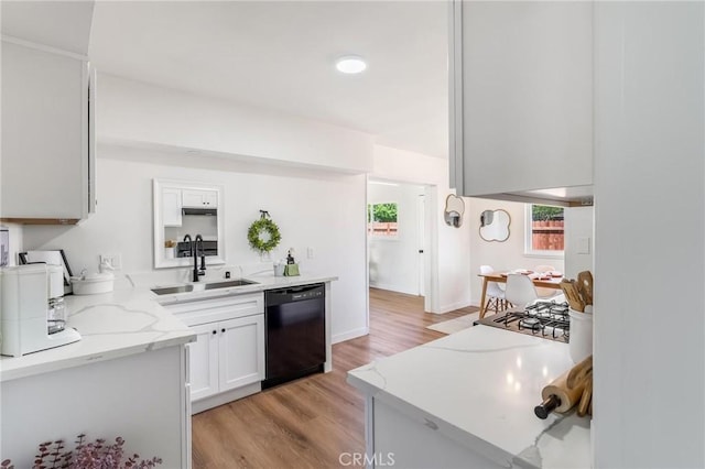 kitchen featuring a sink, black dishwasher, light wood-style floors, and white cabinetry