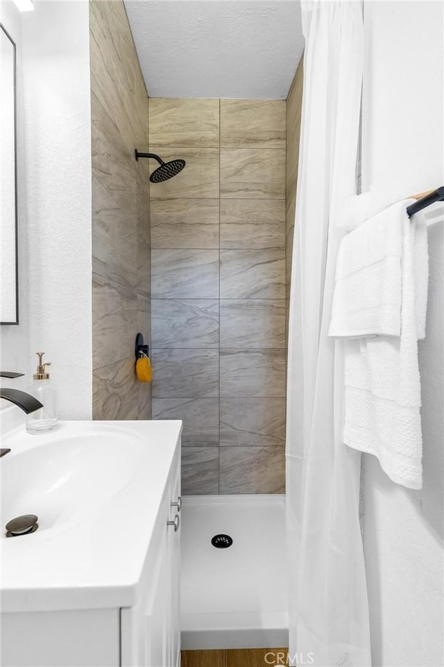 bathroom featuring a shower stall and vanity