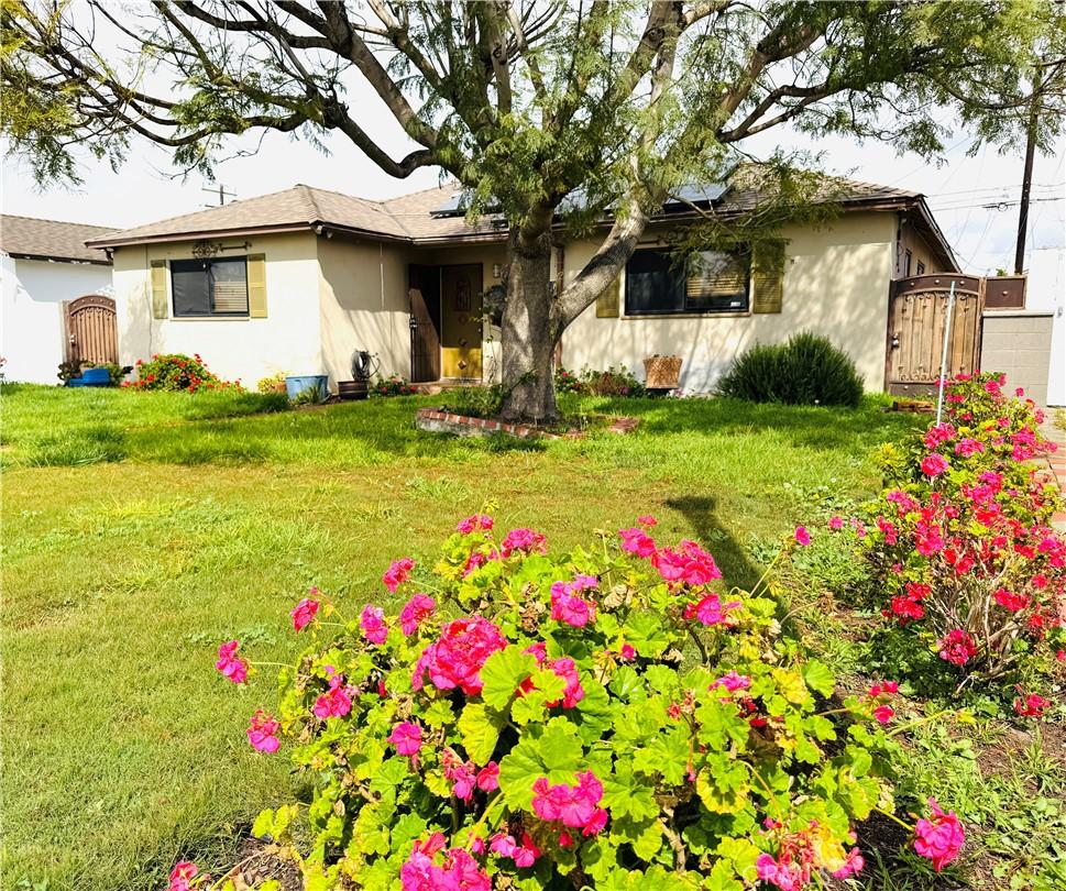 view of front of home with stucco siding, a front lawn, and a gate