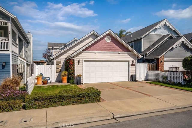 view of front of house featuring concrete driveway, fence, and a garage