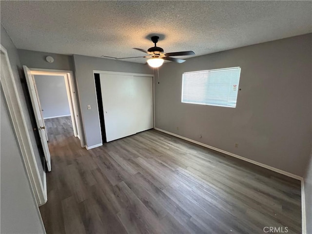 1121 E Whittier Ave, Hemet, CA 92543 - unfurnished bedroom featuring a closet, baseboards, a textured ceiling, and wood finished floors