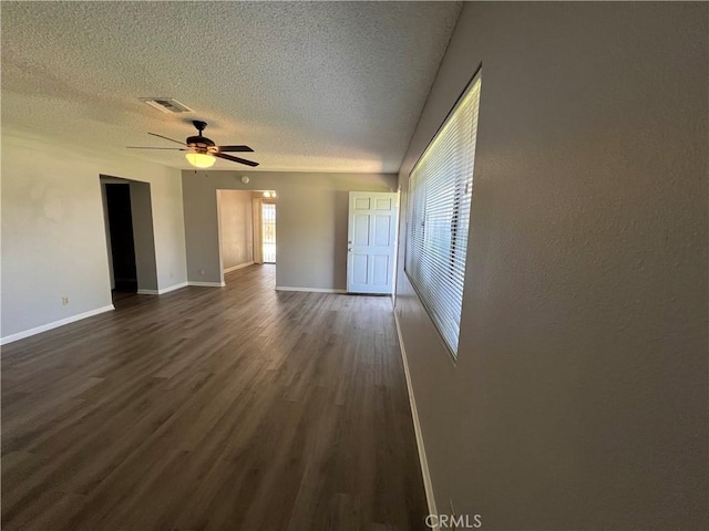 1121 E Whittier Ave, Hemet, CA 92543 - empty room with a ceiling fan, a textured ceiling, visible vents, baseboards, and dark wood-style floors
