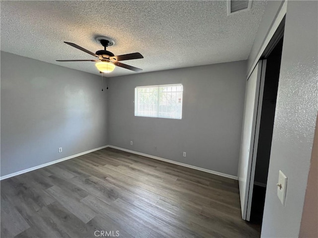 1121 E Whittier Ave, Hemet, CA 92543 - unfurnished bedroom with visible vents, a textured ceiling, dark wood-style floors, and a closet