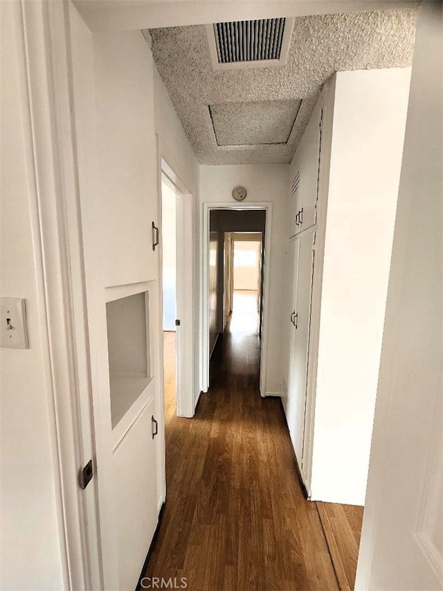 corridor with visible vents and dark wood finished floors