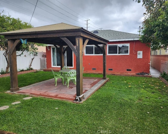 back of house featuring crawl space, a gazebo, a yard, and fence