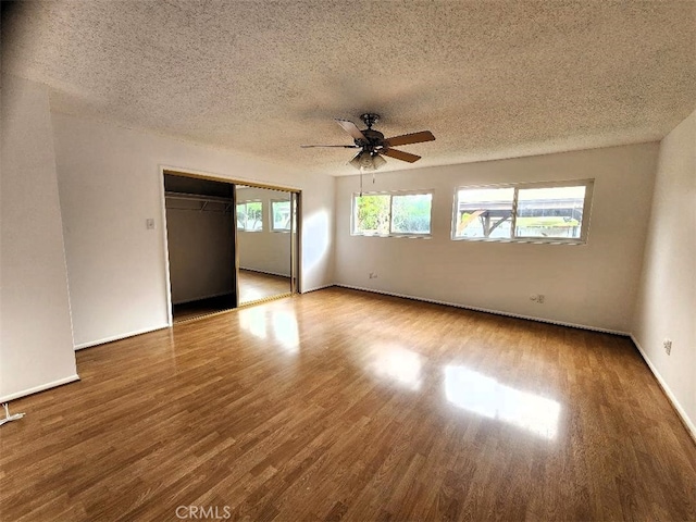 unfurnished room with baseboards, a textured ceiling, a ceiling fan, and wood finished floors