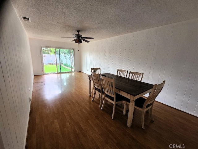 dining area with a ceiling fan, wood finished floors, visible vents, and a textured ceiling