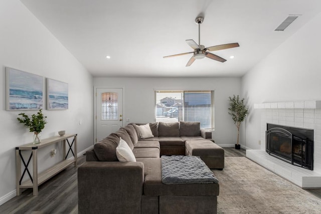 living area featuring baseboards, a brick fireplace, dark wood finished floors, and vaulted ceiling