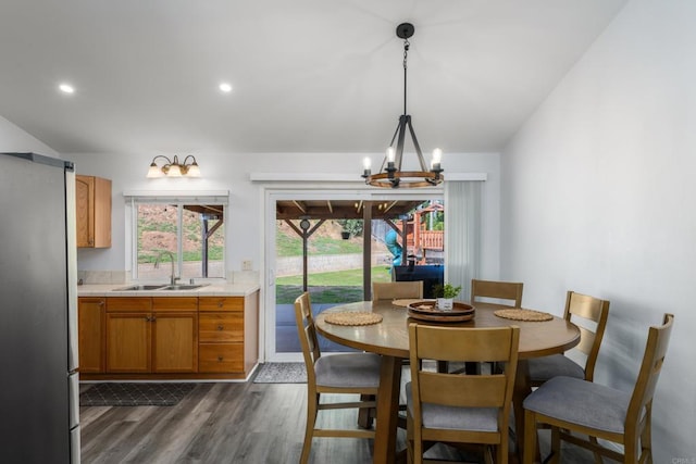 dining area with dark wood-type flooring, a notable chandelier, and recessed lighting