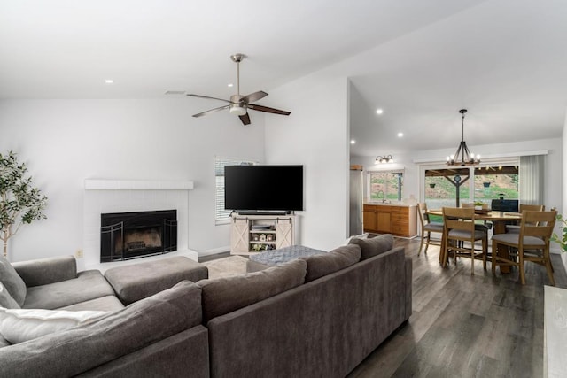 living area with dark wood-type flooring, ceiling fan with notable chandelier, a glass covered fireplace, recessed lighting, and lofted ceiling