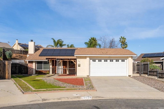 ranch-style home with a porch, solar panels, concrete driveway, and fence