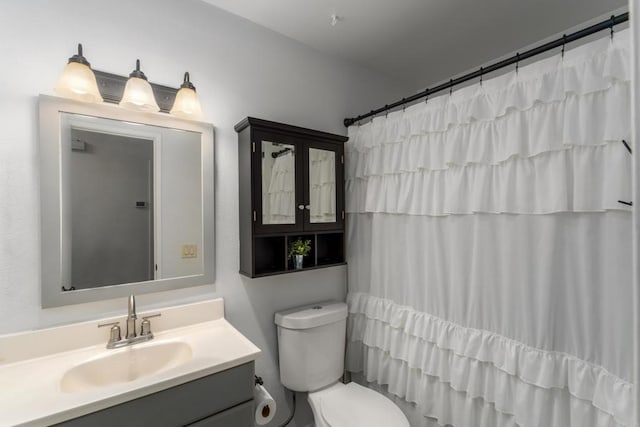 bathroom featuring vanity, curtained shower, and toilet