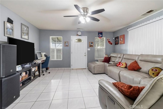 living area featuring light tile patterned floors, a ceiling fan, and visible vents