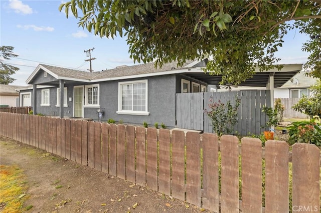 view of front of home featuring fence and stucco siding