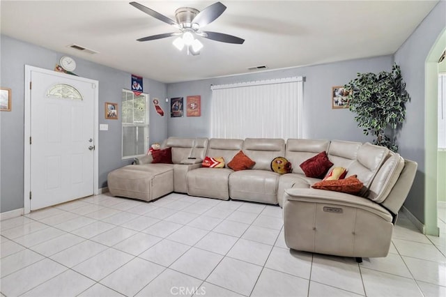 living area with light tile patterned floors, visible vents, baseboards, and ceiling fan