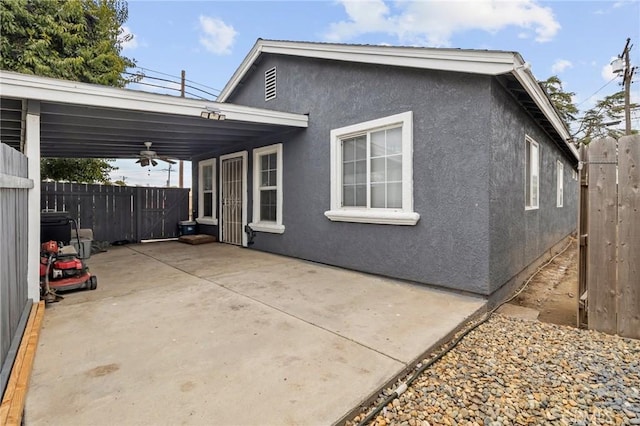 back of house with stucco siding, ceiling fan, a patio, and fence