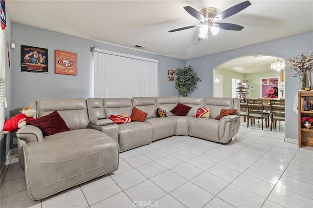 living room with arched walkways, visible vents, ceiling fan, and light tile patterned floors