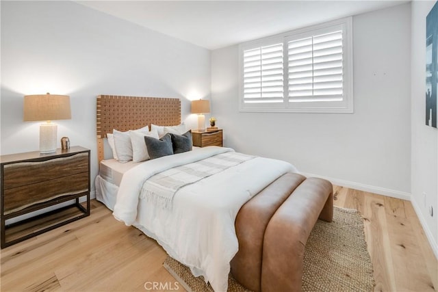 bedroom featuring light wood-style flooring and baseboards