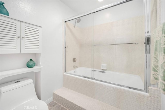 full bathroom with tiled shower / bath, baseboards, and toilet
