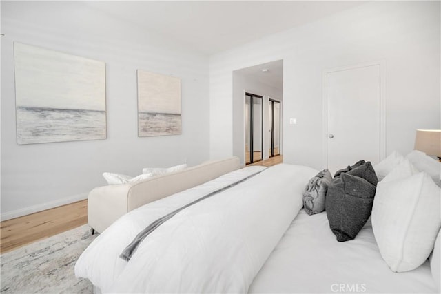 bedroom with baseboards and wood finished floors