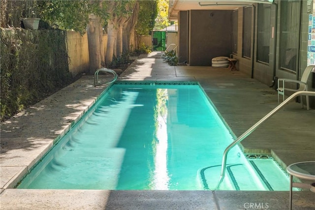 view of swimming pool with a fenced in pool and fence