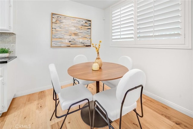 dining room with baseboards and light wood-type flooring