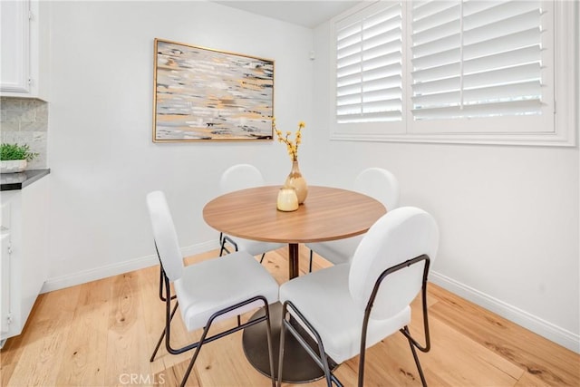 dining area with baseboards and light wood-style floors