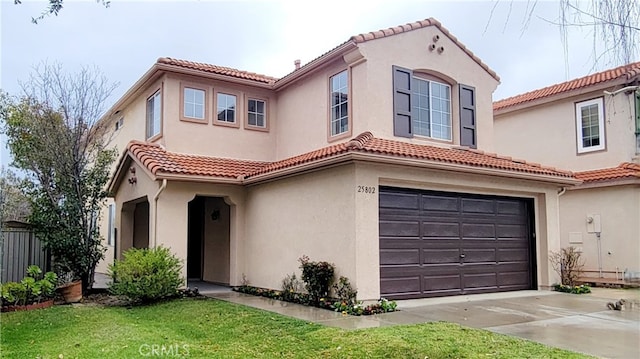 mediterranean / spanish-style home featuring a tile roof, an attached garage, driveway, and stucco siding