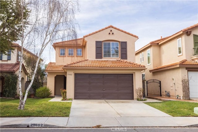 mediterranean / spanish home featuring a tile roof, stucco siding, driveway, an attached garage, and a gate