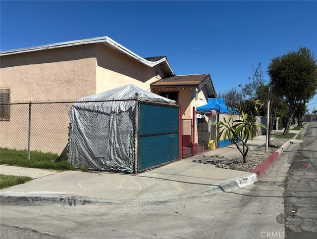 view of side of property with fence and stucco siding