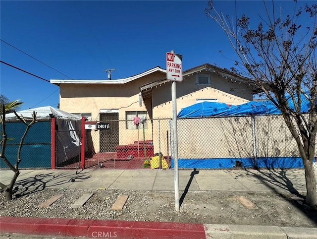 exterior space with a fenced front yard, stucco siding, and a gate