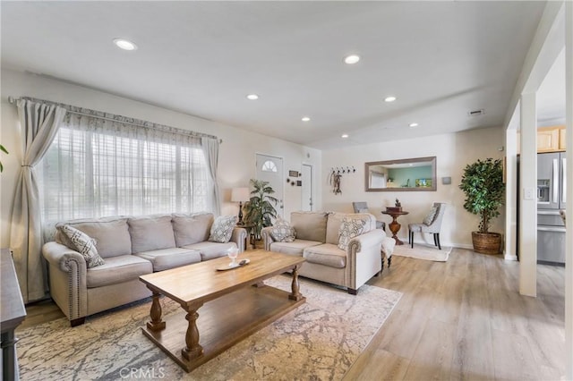 living room with recessed lighting, baseboards, and light wood-style floors