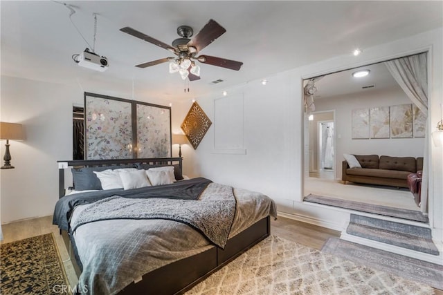 bedroom featuring visible vents, a ceiling fan, and wood finished floors