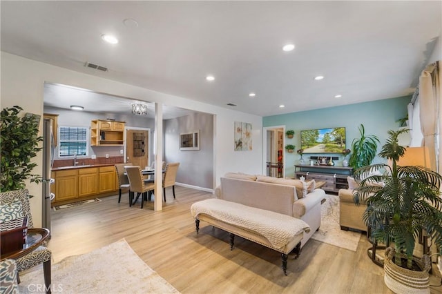 living area featuring recessed lighting, light wood-style floors, visible vents, and baseboards