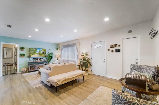 living room with light wood finished floors, visible vents, recessed lighting, and baseboards