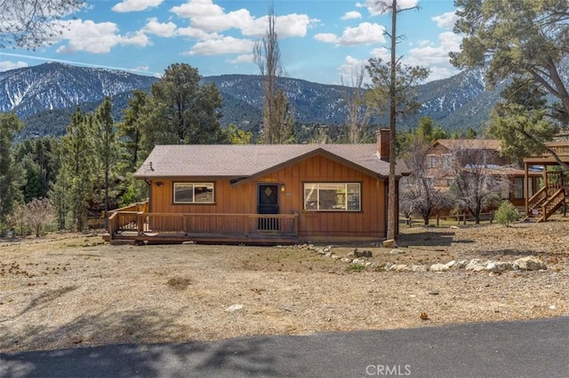 rustic home with a mountain view, board and batten siding, and a chimney