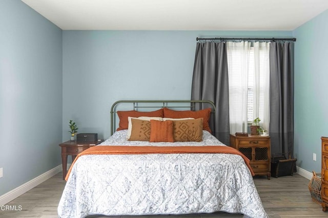 bedroom with baseboards and wood finished floors