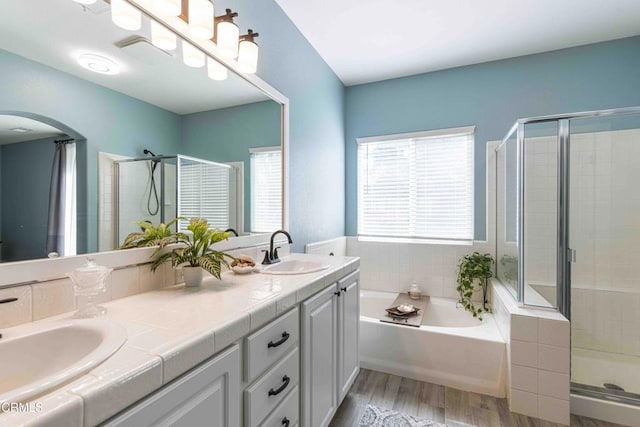 bathroom featuring a sink, wood finished floors, and a stall shower