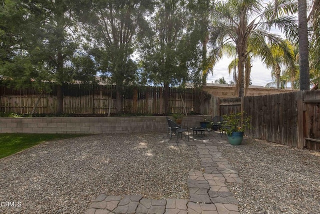 view of yard featuring a patio, a fenced backyard, and an outdoor fire pit