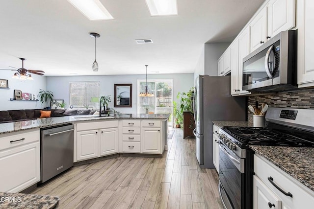 kitchen featuring a sink, stainless steel appliances, visible vents, and white cabinetry